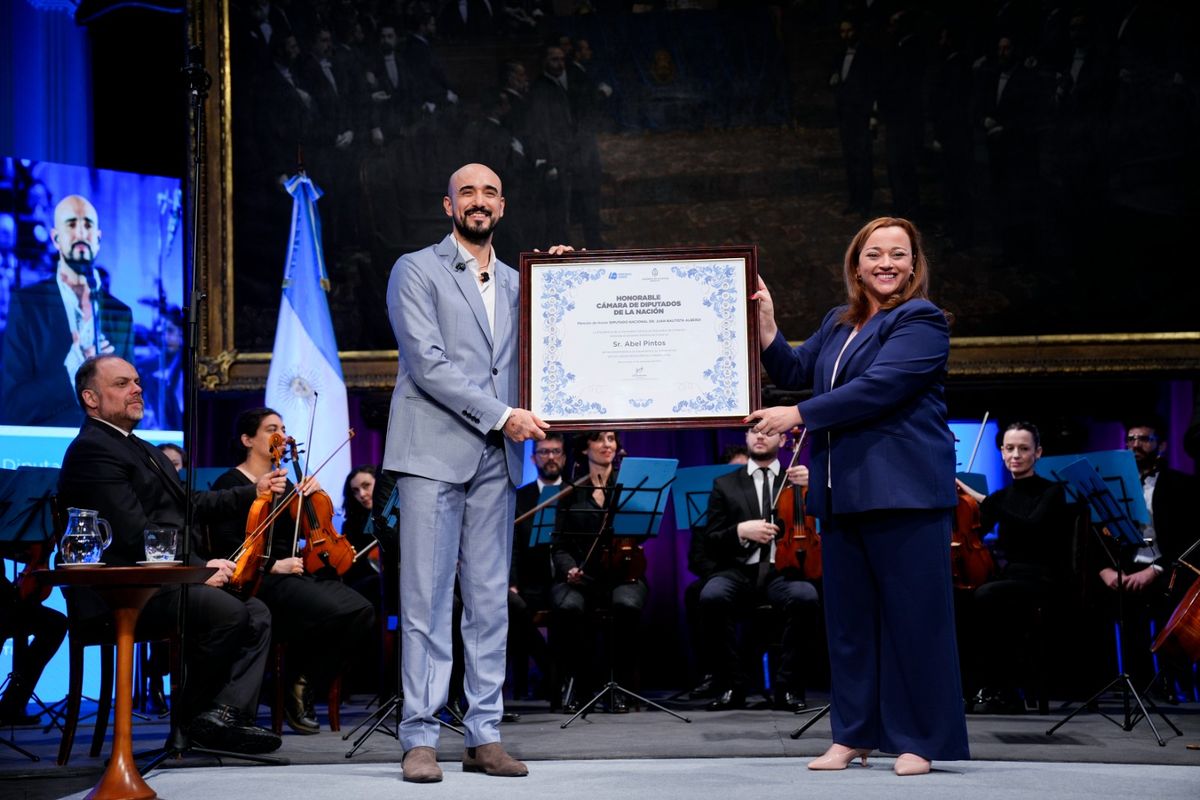 La Presidenta de la Cámara de Diputados Cecilia Moreau entrega el reconocimiento al cantante popular Abel Pintos.