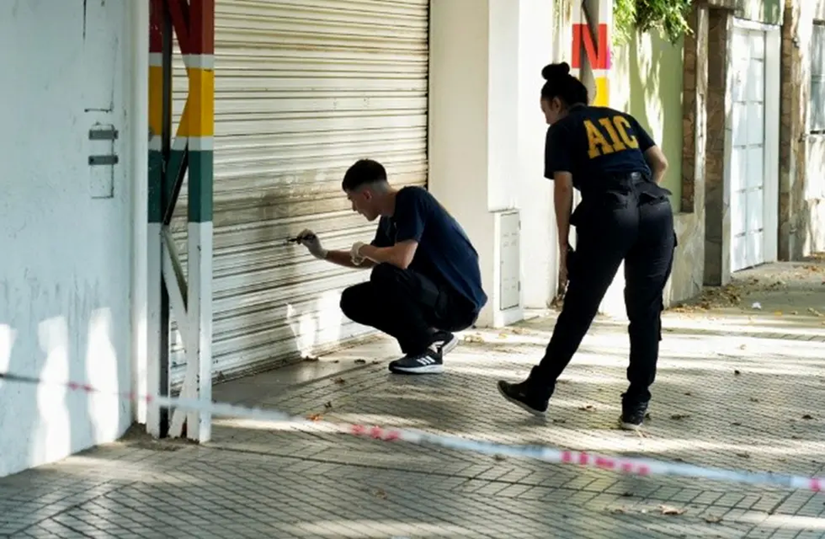 Los investigadores peritan la persiana del súpermercado atacado. Foto: Rosario3